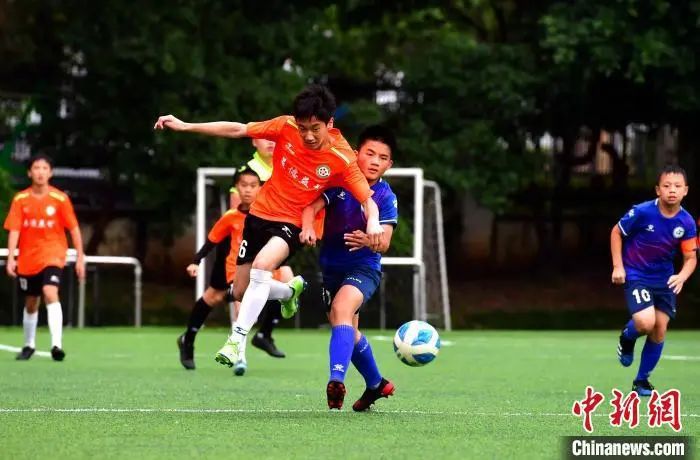 图为2021年5月9日，福州市仓山区第五中心小学，来自该校的选手与福建西山学校的选手(蓝衣)在比赛中争抢。张斌 摄
