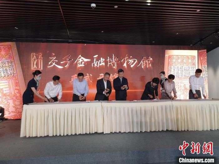 嘉宾在交子金融博物馆书法卷轴上加盖印章，宣布正式开馆。杜成 摄