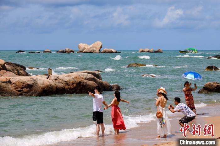 资料图：游客在天涯海角的海边沙滩“拥抱大海”。　范勇 摄
