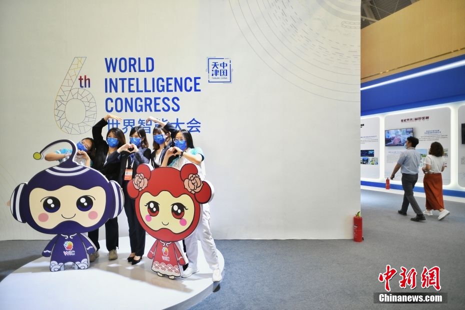 图为与会者与世界智能大会吉祥物“智多”和“智悦”合影。 中新社记者 佟郁 摄