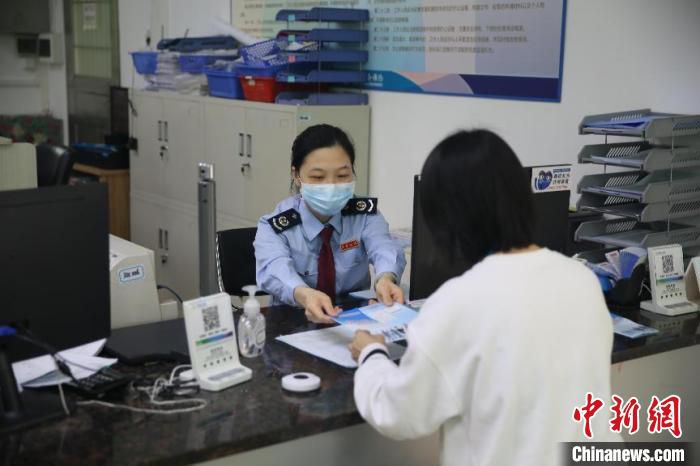 图为江门高新区税务人员向缴费人派发社保费缓交宣传小册子 杨伟 摄