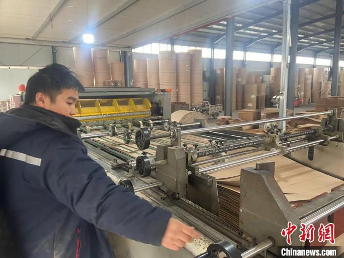 平乡县一家档案用品有限公司的工人正在进行纸板压制。　李超 摄