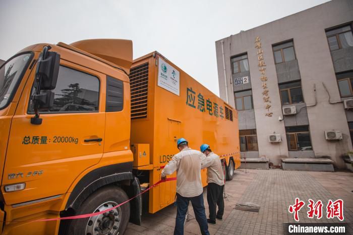 图为国网北京石景山供电公司发电车运行人员在区考试中心开展发电车接入工作。 李强 摄 图为国网北京石景山供电公司发电车运行人员在区考试中心开展发电车接入工作。 李强 摄