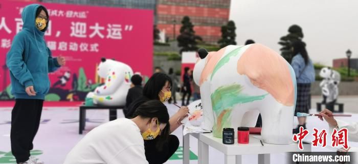 四川高校师生在大运村彩绘大熊猫。　成都大学供图