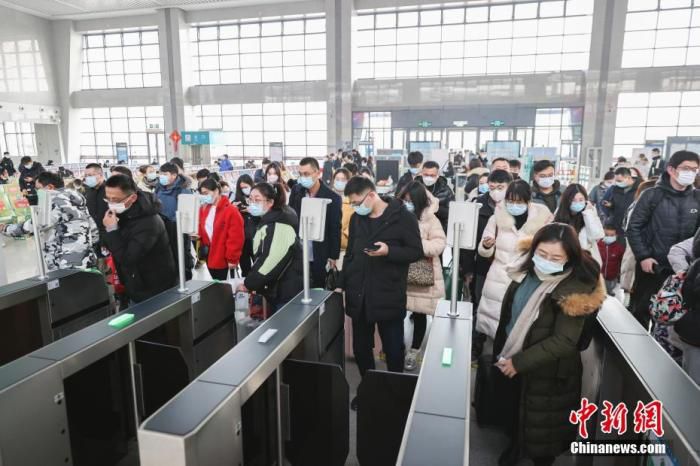 2022年1月3日，旅客在江苏连云港市赣榆火车站进站乘车。当日是元旦假期最后一天，全国铁路迎来返程客流高峰。 中新社发 司伟 摄 图片来源：CNSPHOTO