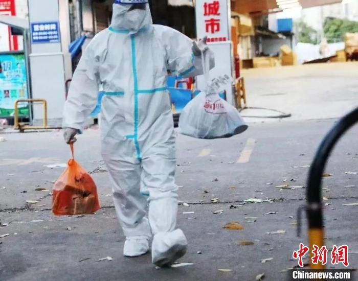 图为封控区物资配送到小区外围后 志愿者往返送给居民 广西商务厅供图