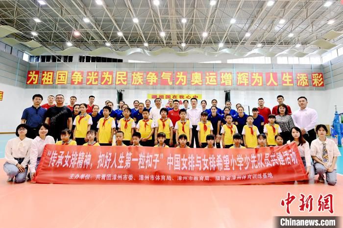 中国女排与女排希望小学少先队员合影。　张金川 摄