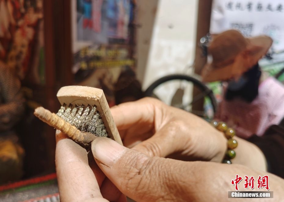 图为6月12日，西宁市一冬虫夏草市场内的短工用刷子刷冬虫夏草上的泥土。 中新社记者 张添福 摄