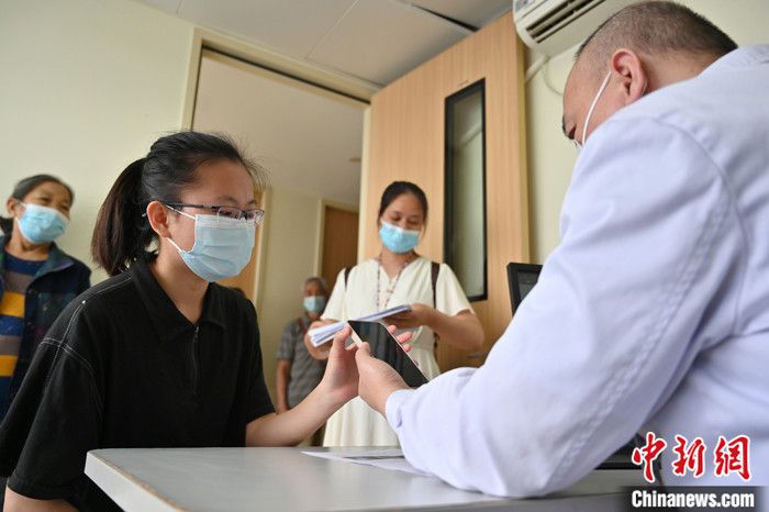 图为4月26日，广西南宁，“00后”职业陪诊员曾秀秀拨通视频电话，让异地的患者与医生沟通病情。 中新社记者 俞靖 摄