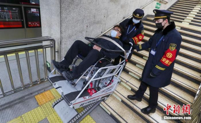 3月1日，北京地铁1号线五棵松站，一名使用轮椅的乘客在车站工作人员的协助下使用轮椅升降平台进站。目前北京地铁公司已完成轮椅升降平台和爬楼车的更新和补充，这些设备已经全面投入使用。 中新社记者 贾天勇 摄