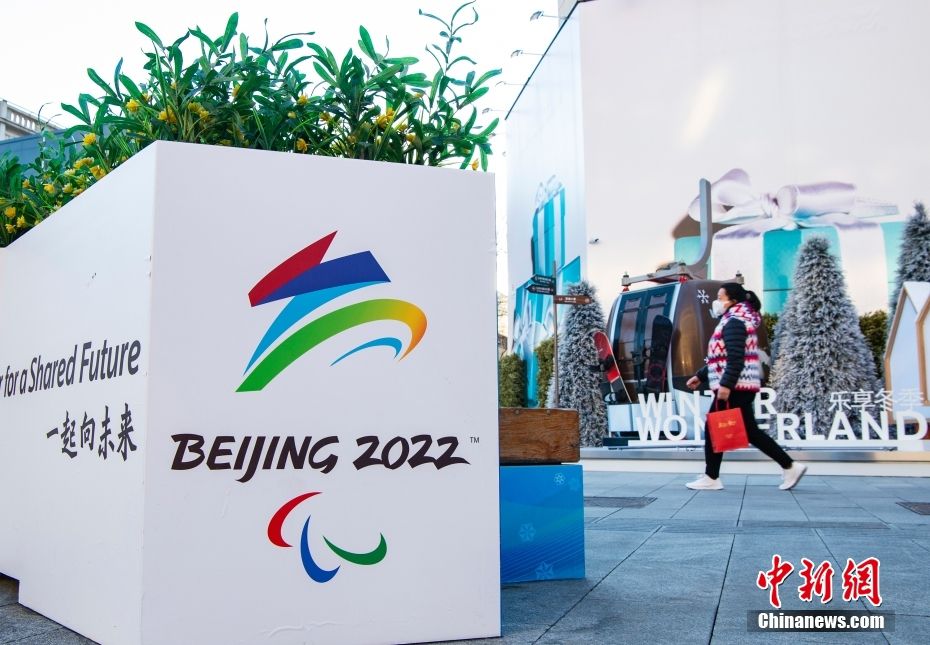 图为市民经过北京市王府井步行街上布置的北京冬残奥会会徽标志。 中新社记者 侯宇 摄