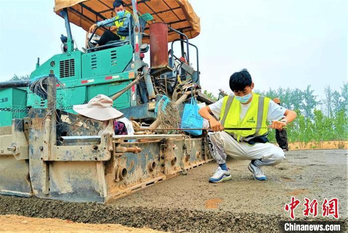 技术员正在对路水稳层铺设厚度进行测量。　睢宁县委宣传部供图