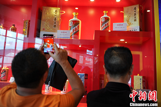 市民在茅台酒展台前用手机拍摄展出的茅台酒瓶。(资料图) 中新社记者 贺俊怡 摄