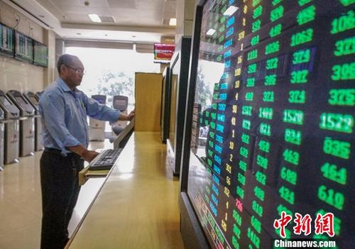 资料图：海口某证券公司营业部的股民关注股市动态。中新社记者 骆云飞 摄