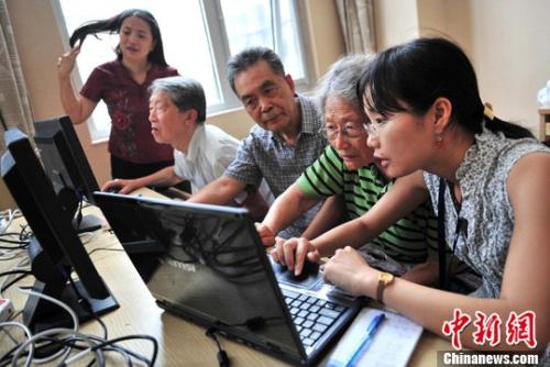 资料图：志愿者为福利院几位老人辅导电脑上网入门知识。中新社发 邹宪 摄